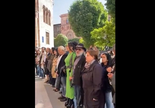 Деятели культуры исполняют песню напротив оцепленного полицейскими здания правительства Армении