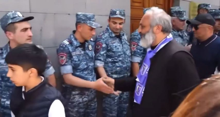 Archbishop Bagrat greets police officers outside parliament