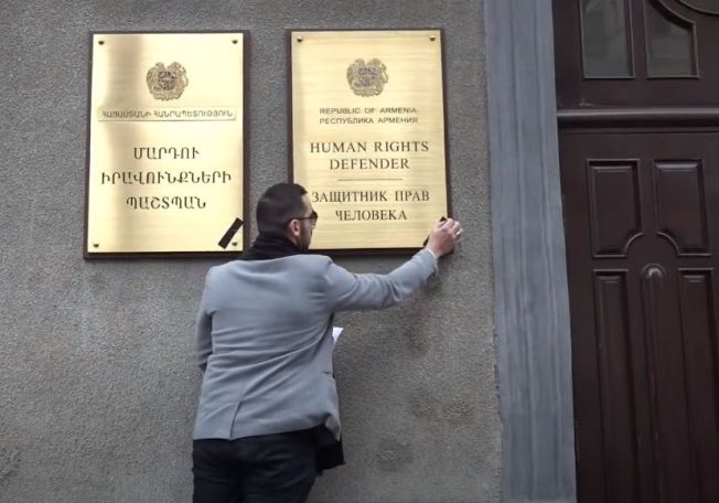 Активист Самвел Варданян прикрепил черную ленту на табличку с надписью «Защитник прав человека»