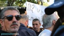 Police detain a citizen protesting against the planned 'colorful celebration' of Independence Day
